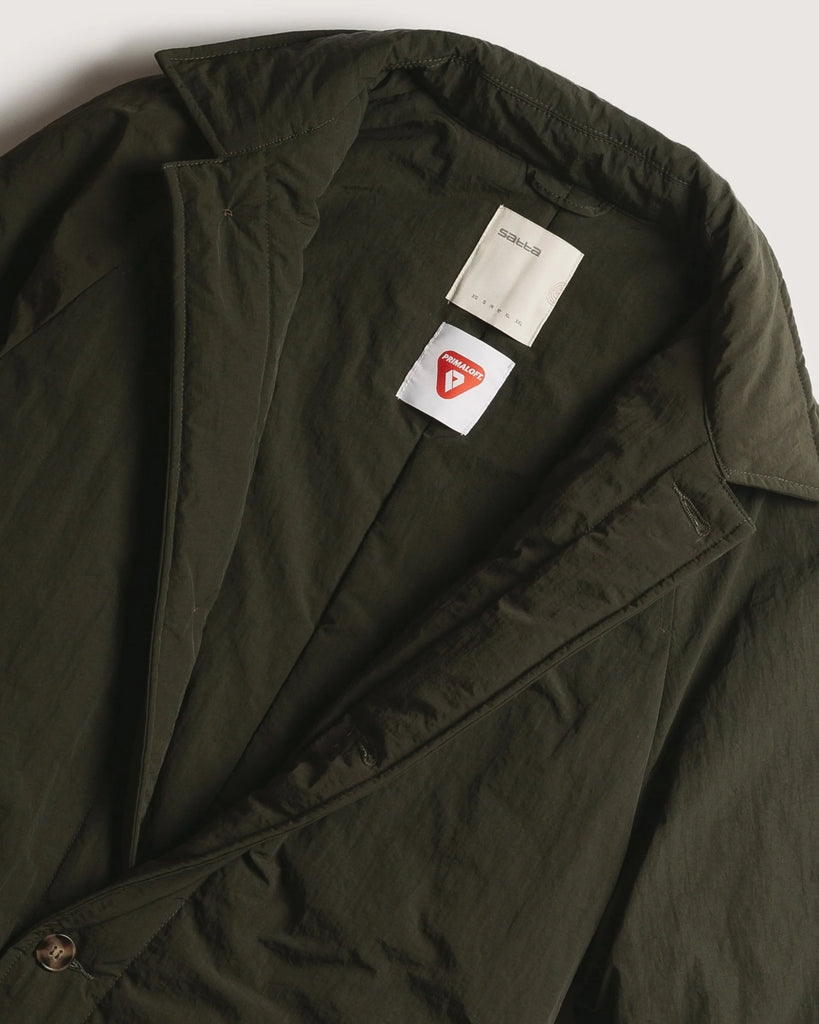 close up of green trench coat showing the open color and tortoise buttons