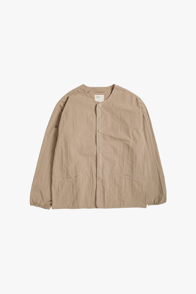 peached thin collarless dojo liner in a light beige color from satta. Feels rigid and sturdy to the touch and while wear in and shape to the wearer over time.