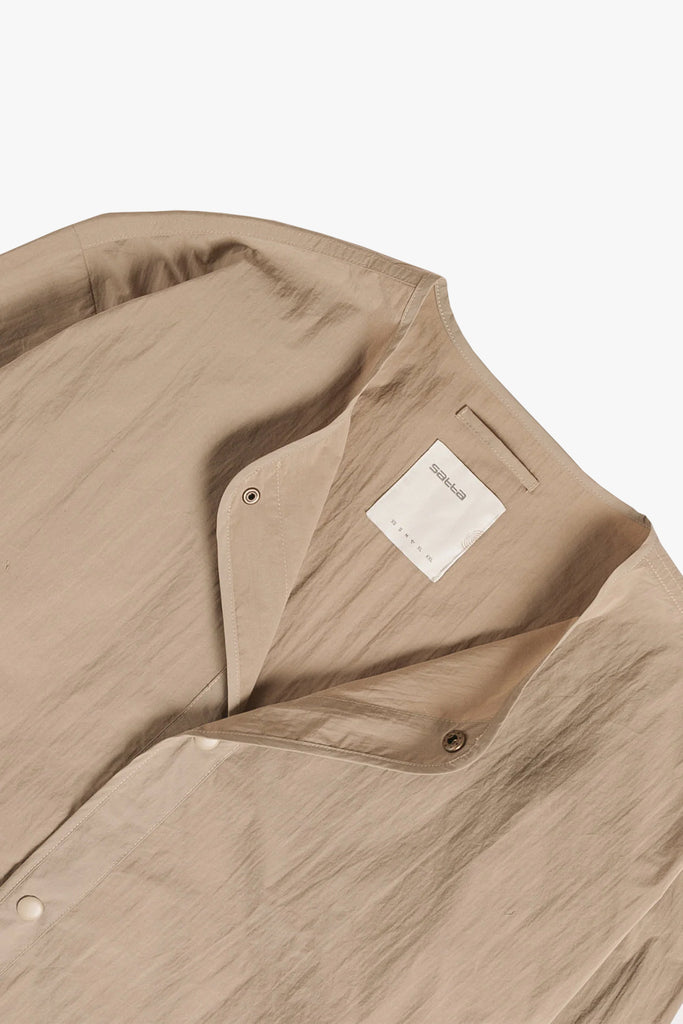 close up image of the dojo liner in beige showing the button closures